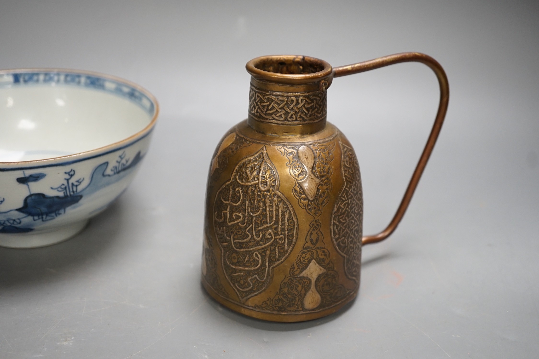 A Chinese Ming dynasty internally decorated porcelain tea bowl, an 18th century blue and white bowl, two other blue and white bowls, a similar water pot and an Islamic brass vessel